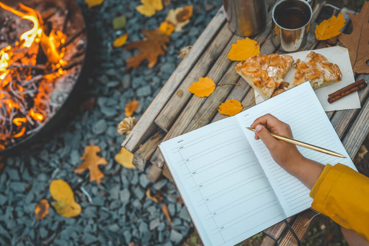 Herbstbucketlist auf einer Bank mit Stift und Blättern