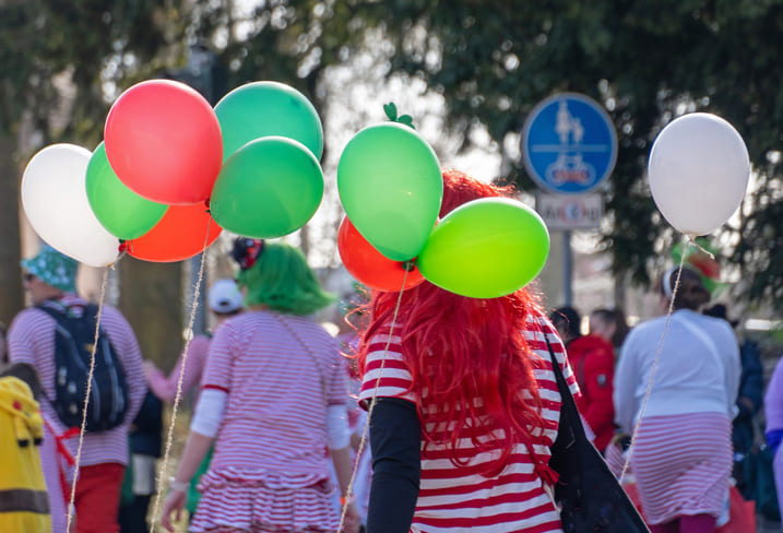 Faschingsumzug in Bamberg. Eine Fußgruppe von hinten mit Luftballons und bunten Kostümen.
