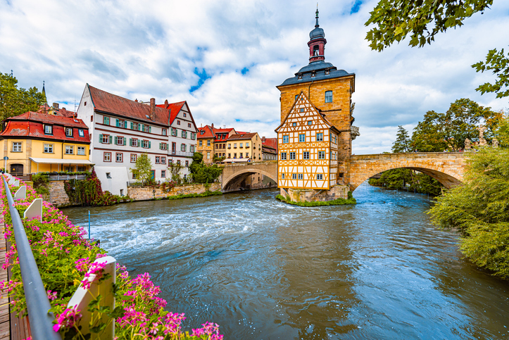 Blick auf das Bamberger Rathaus über dem Wasser.