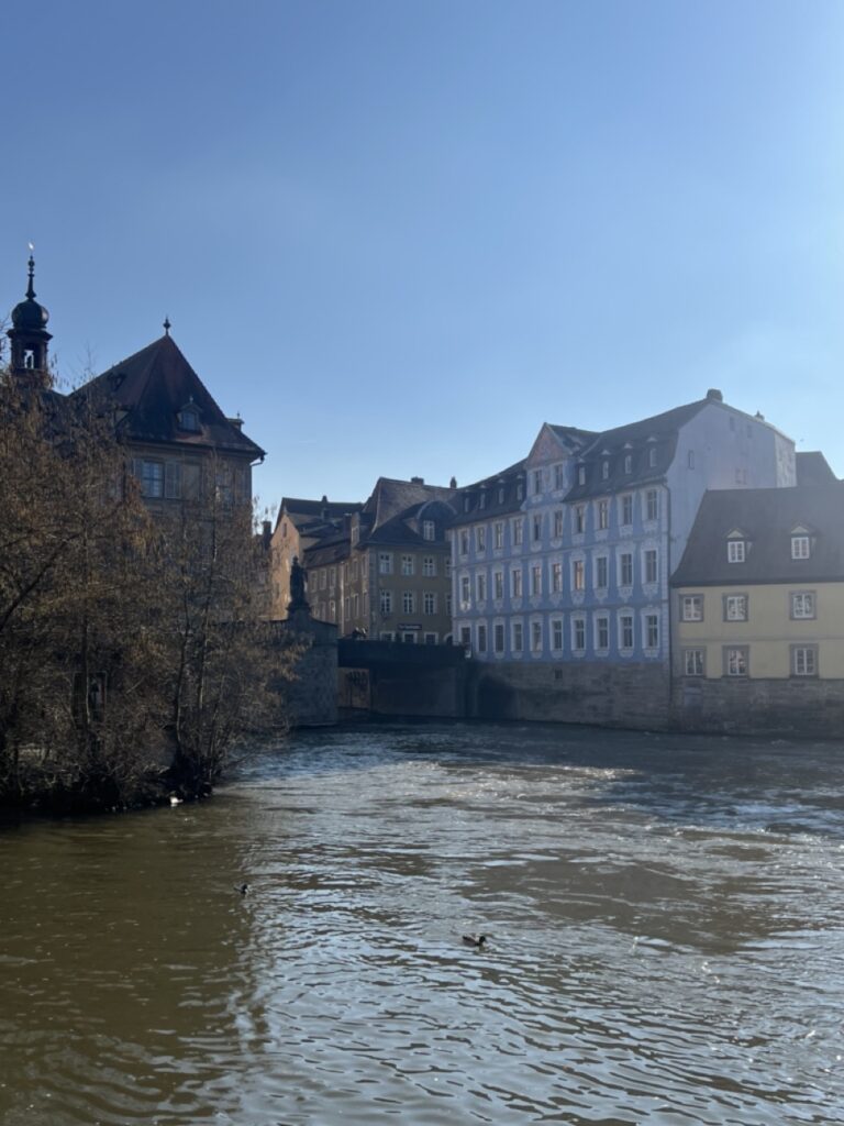 Bild vom Frühling in Bamberg von der Regnitz und der unteren Brücke mit viel Sonnenstrahlen. 