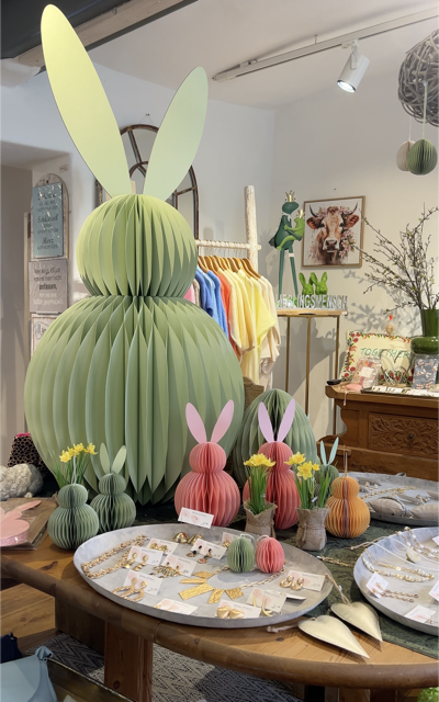 Osterdekoration aus Papier und angebotener Goldschmuck in der Auslage.