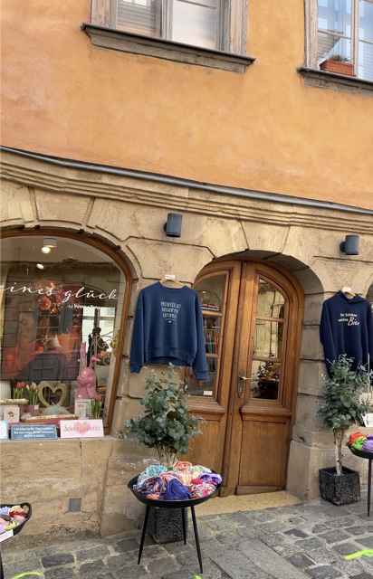 Außenansicht auf den Laden Kleines Glück mit Angeboten des Geschäfts vor der Tür.