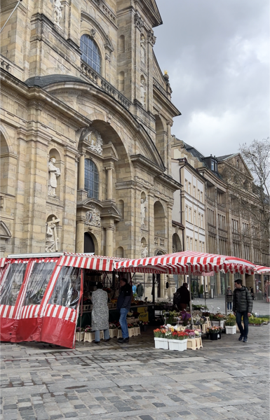 Kulisse des Bamberger Wochenmarkts. Blick auf die Marktstände auf dem Grünen Markt vor der Kirche.